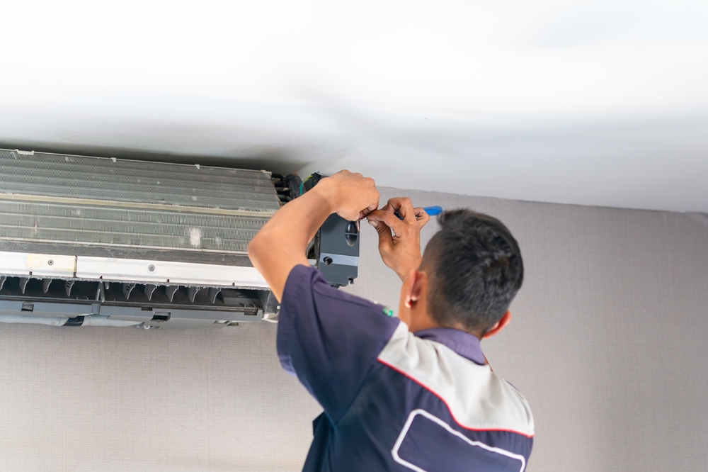 On The Double technician performing AC maintenance tasks
