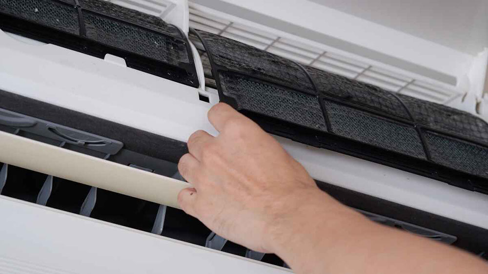 a person changing AC filters