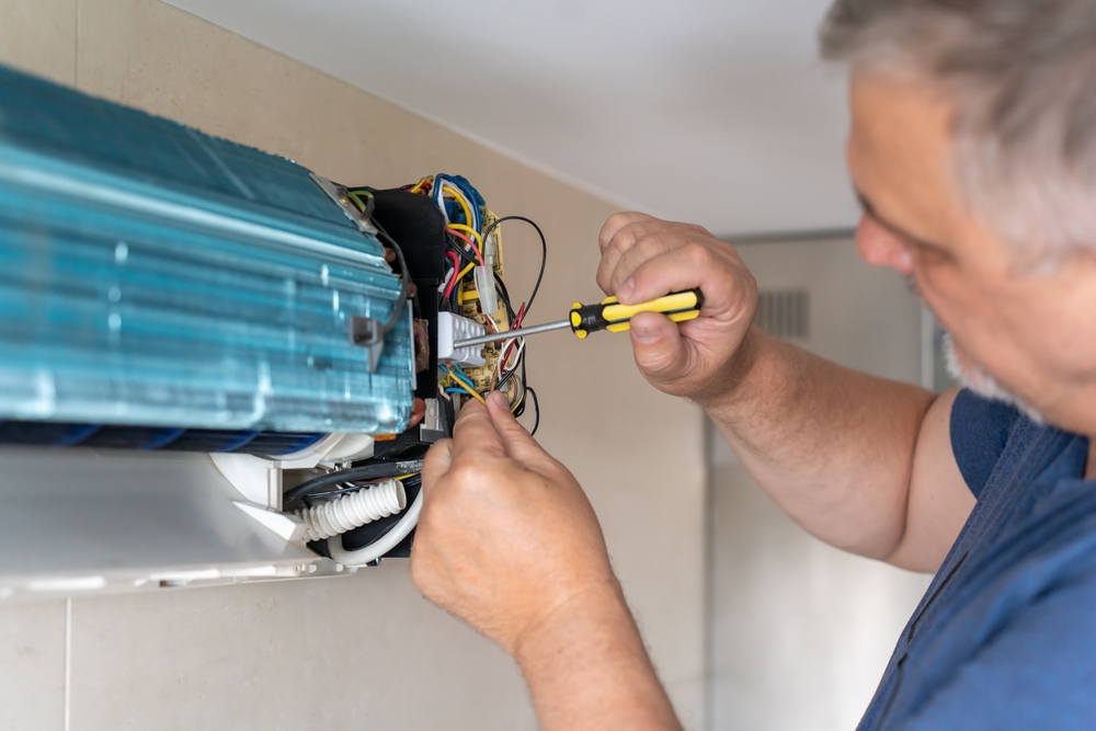 HVAC tech repairing an AC