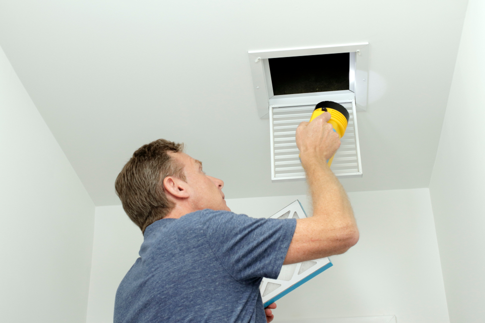 homeowner looking at HVAC ductwork